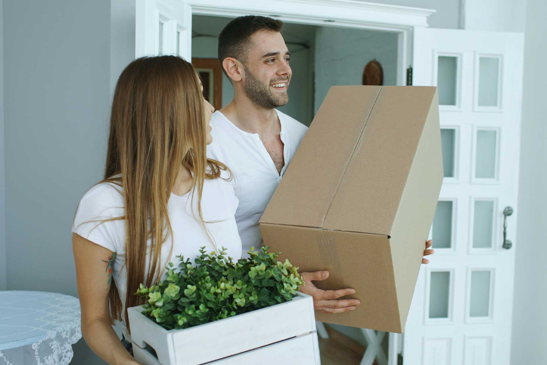 young couple carrying moving boxes