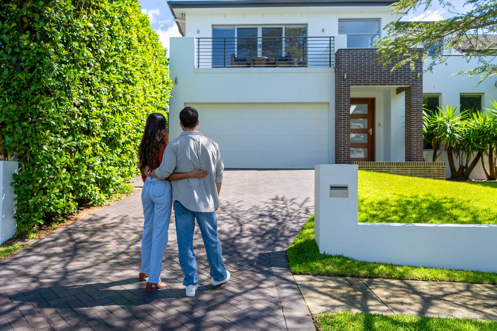 couple standing in driveway of new home