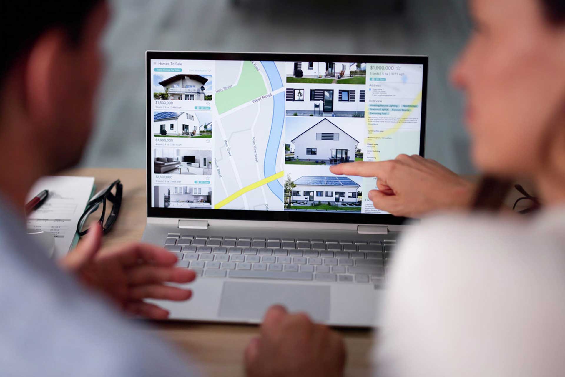 couple looking at home listings on laptop computer